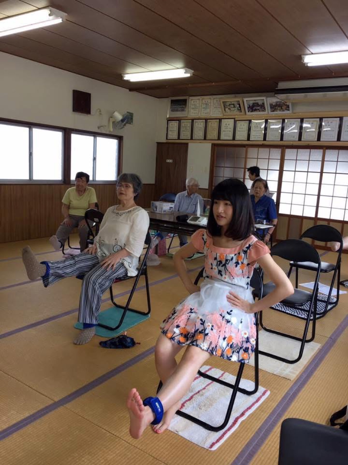 椅子に座って一緒に体操をする参加者たち