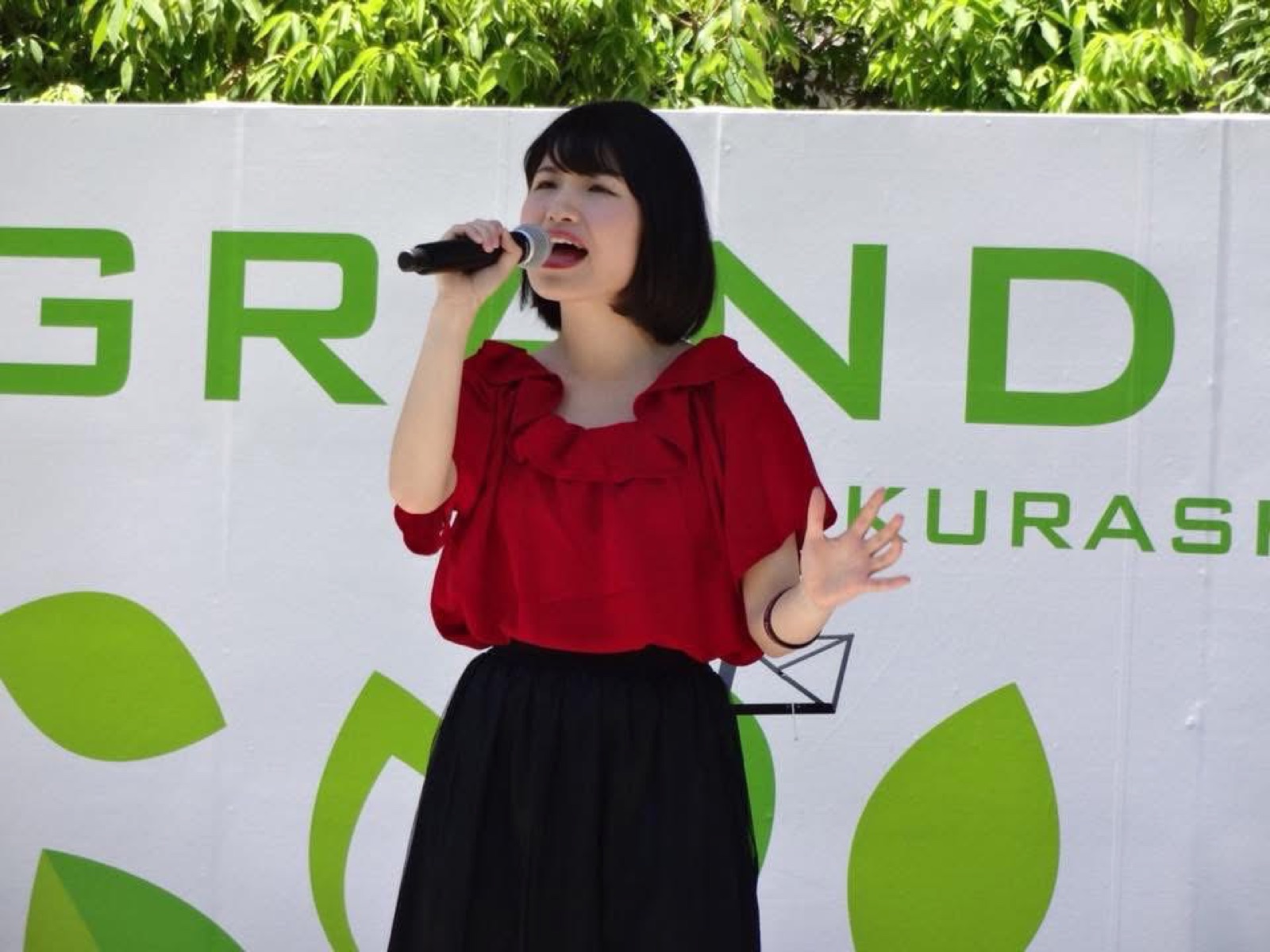 屋外イベントのステージで歌う木村千鶴
