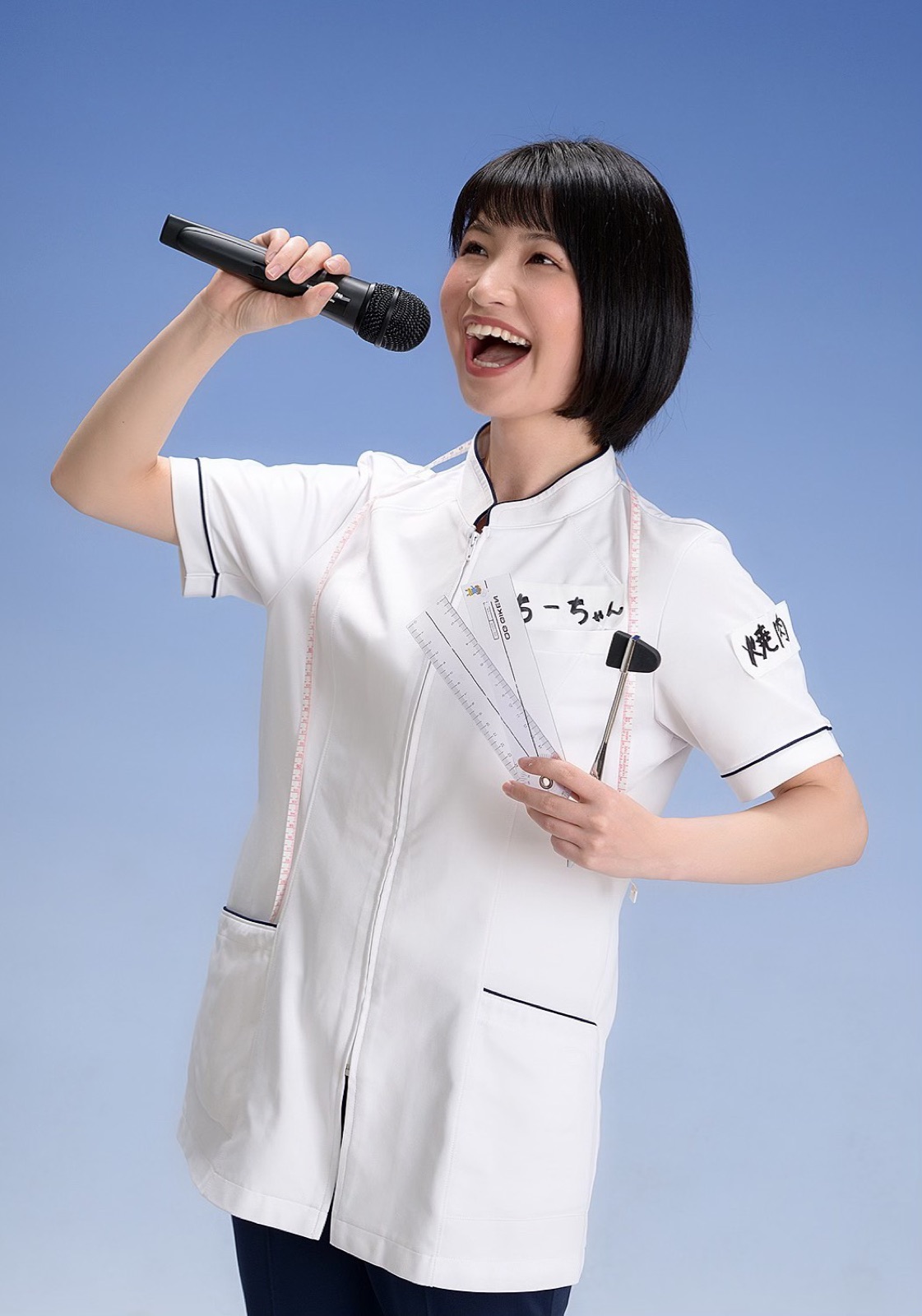 白衣を着てマイクを持つ木村千鶴